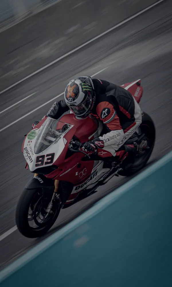 Piloto tumbado en curva con una superbike roja
