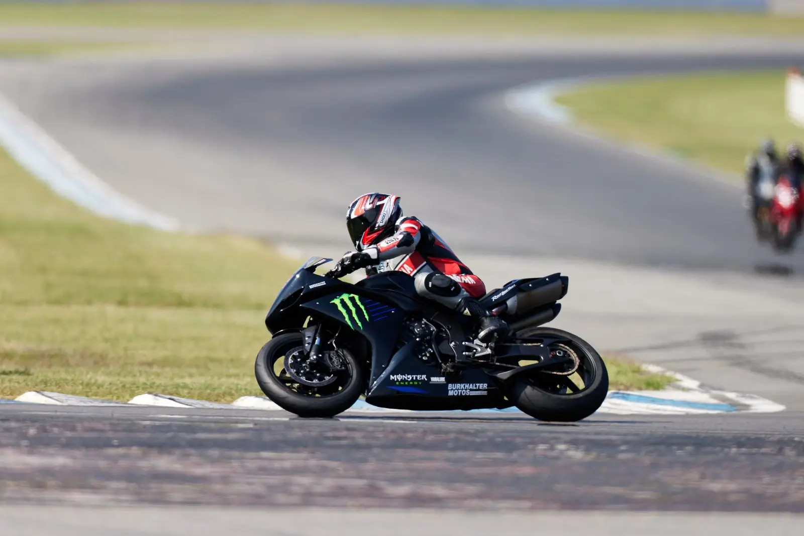 Moto deportiva negra inclinada en una curva del circuito
